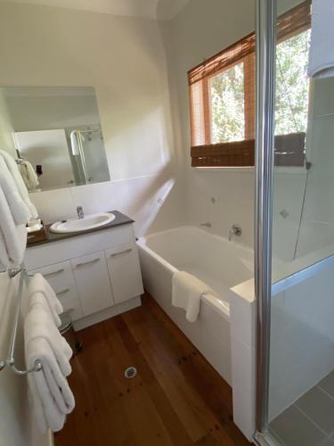 a white bathroom with a tub and a sink at Balmoral 575 in Montville