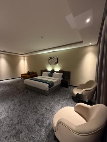 a hotel room with a bed and two chairs at Belvedere Hotel in Al Madinah