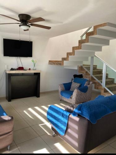 a living room with a couch and a staircase at Casa en bosques de San Juan in San Juan del Río
