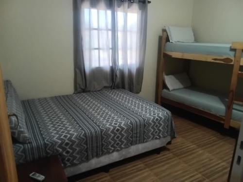 a bedroom with a bed and a couch and a window at Apart Encanto Iguazú in Puerto Iguazú