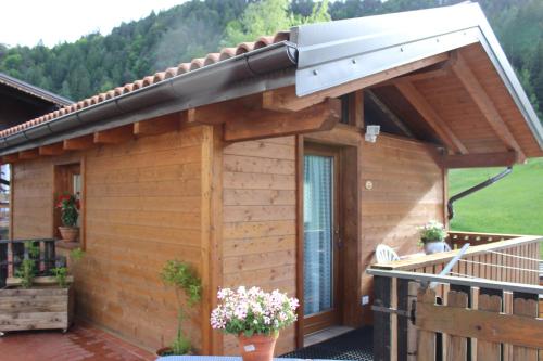 a wooden cabin with a porch and a balcony at B&B La Genzianella in Perarolo di Cadore