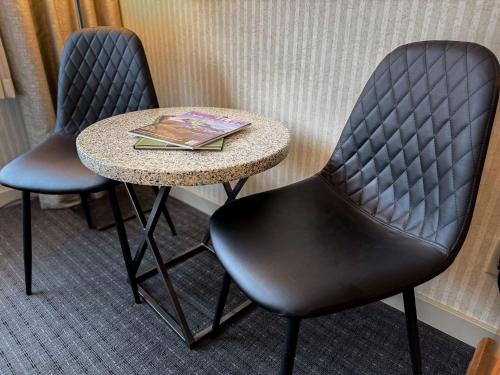 two chairs and a table in a hotel room at Listel Whistler, a Coast Hotel in Whistler
