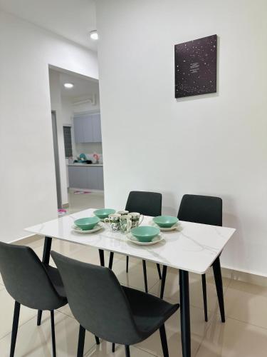 a white table with green bowls and chairs at Bayu Temiang - 5pax Quiet Home in Seremban