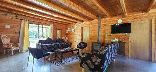 a living room with a couch and a tv at Casa Verde in Coñaripe