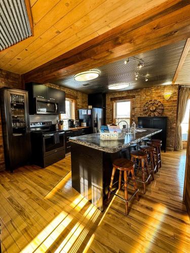 a kitchen with a large island with bar stools at THE LOFT 3 level urban cabin with a HUGE patio! in Willmar