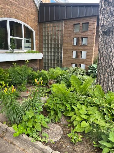 a garden with flowers and plants in front of a building at THE LOFT 3 level urban cabin with a HUGE patio! in Willmar