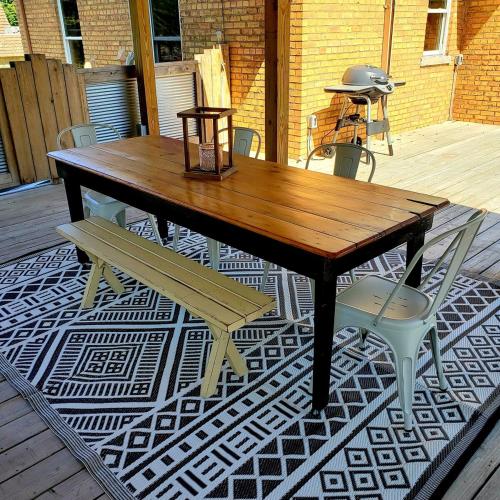 a wooden table and two chairs on a patio at THE LOFT 3 level urban cabin with a HUGE patio! in Willmar