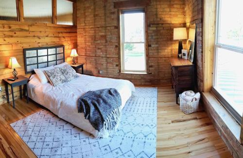 a bedroom with a bed and two windows at THE LOFT 3 level urban cabin with a HUGE patio! in Willmar