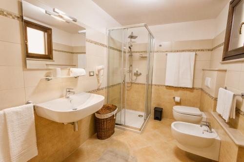 a bathroom with a sink and a toilet and a shower at Le Radici in Uggiano la Chiesa