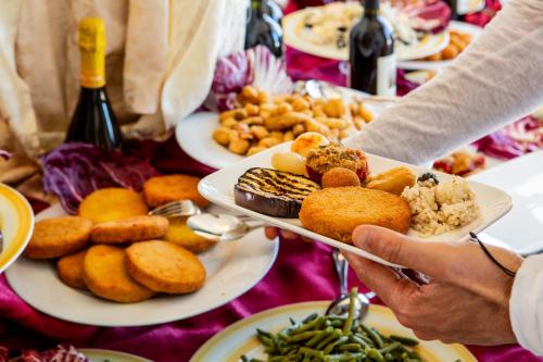 a person holding a plate of food on a table at Hotel Lungomare in Cervia
