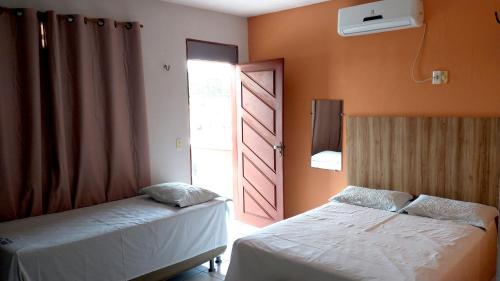 ein Schlafzimmer mit 2 Betten und einer offenen Tür in der Unterkunft Pousada Lunar in Parnaíba