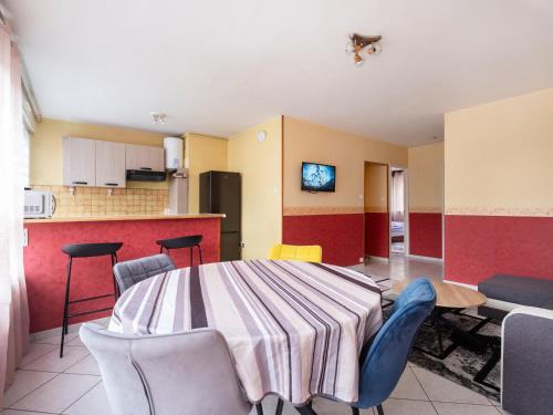 une pièce avec une table et des chaises et une cuisine dans l'établissement Le Chatoyant - À 15 minutes de la Place Stanislas - NyuLocation, à Nancy