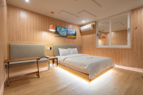 a bedroom with a bed and a desk in it at Hotel Yoegieottae Gwangju Station in Gwangju