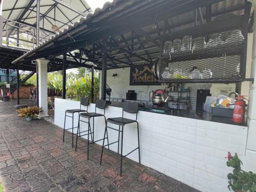 an outdoor kitchen with stools at a counter at Aeden Villa Roomstay & Homestay in Kuala Kangsar