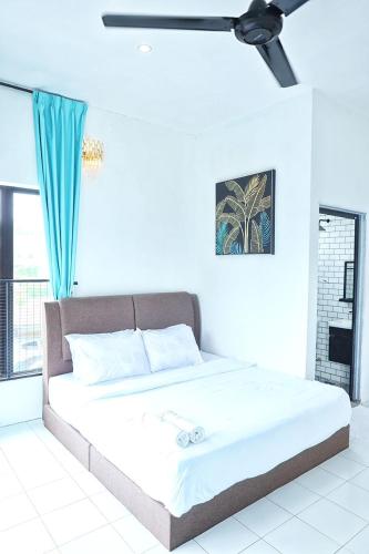 a bed in a white room with a ceiling fan at Aeden Villa Roomstay & Homestay in Kuala Kangsar