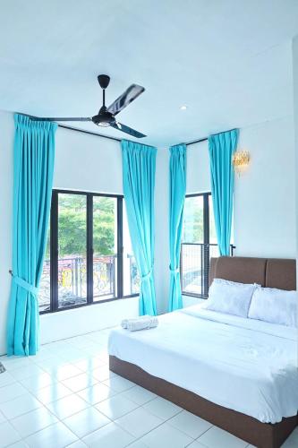 a bedroom with blue curtains and a bed and a window at Aeden Villa Roomstay & Homestay in Kuala Kangsar