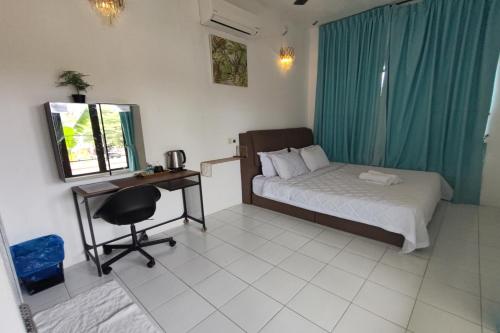 a bedroom with a bed and a desk with a computer at Aeden Villa Roomstay & Homestay in Kuala Kangsar