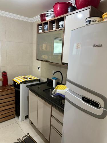 a kitchen with a white refrigerator and a sink at Apto aconchegante nos Bancários 65m in João Pessoa