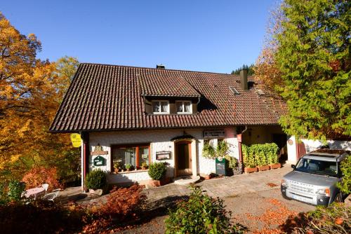 una casa con un coche aparcado delante de ella en Café Pension Waldfrieden, en Bad Peterstal-Griesbach