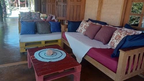 a room with two beds and a table with a candle on it at Chácara Morro da Pedra in Cavalcante