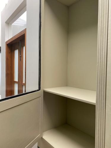 a walk in closet with a window and shelves at Agung Guest House by RF in Timuran