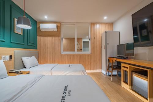 a hotel room with two beds and a television at Hotel Yoegieottae Gwangju Station in Gwangju