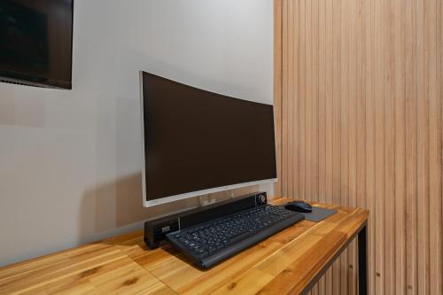 a computer monitor and a keyboard and mouse on a desk at Hotel Yoegieottae Gwangju Station in Gwangju