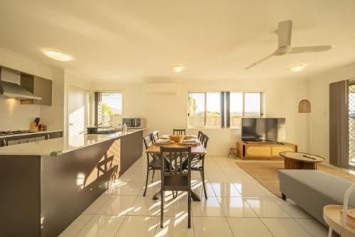 a kitchen and living room with a table and chairs at Peaceful Retreat - Spacious Family Home in Yarrabilba perfect for Family or Professionals in Logan Village