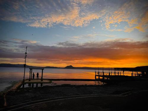 two people are standing on a dock at sunset at Club Balai Isabel Taal Lakeview 305 Malvar in Talisay