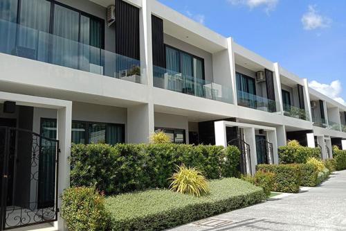 een groot wit gebouw met struiken ervoor bij villa kamala regent 2 bedrooms in Kamala Beach