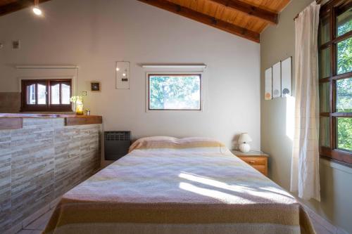 ein Schlafzimmer mit einem Bett und einem Fenster in der Unterkunft Grace in Villa General Belgrano
