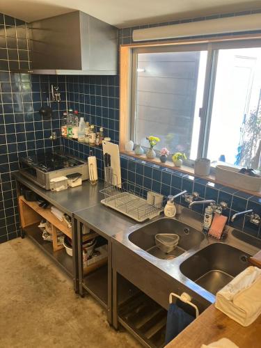 a kitchen with a sink and a counter top at Trawl Guesthouse トロールゲストハウス Breakfast Options in Koshigoe