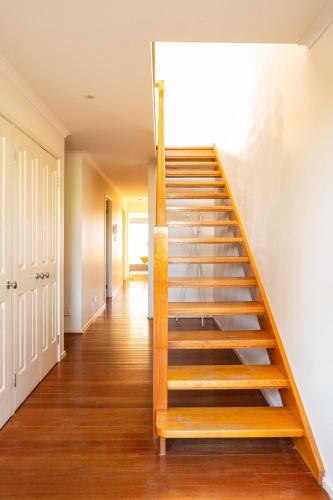 a staircase in a house with wooden steps at Glorious 3-BRM Family House at Aspendale Beach in Aspendale