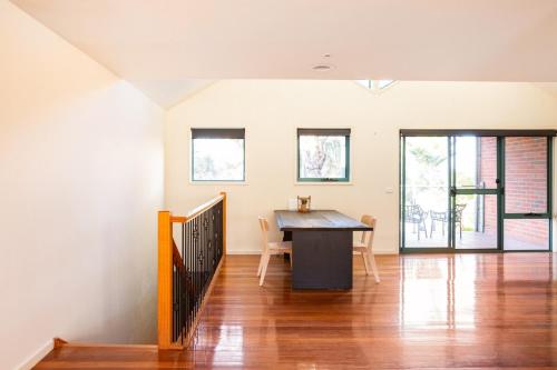 a dining room with a table and some windows at Glorious 3-BRM Family House at Aspendale Beach in Aspendale