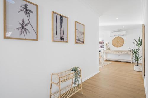 ein Flur mit einer Treppe mit drei Bildern an der Wand in der Unterkunft Blanc 1 in Crescent Head