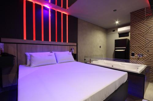 カンピーナスにあるMisk Motel 2のベッドルーム1室(ベッド1台、バスタブ、ベッド1台、バスタブ付)