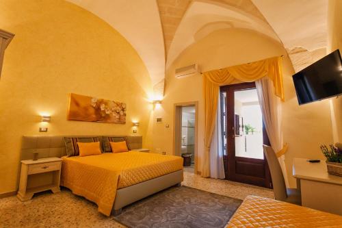 a bedroom with a bed and a tv in a room at Le Radici in Uggiano la Chiesa