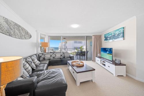 un salon avec un canapé et une télévision dans l'établissement Seaside Serenity - Apartment Ocean Views, à Caloundra