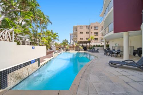 une piscine dans la cour d'un immeuble dans l'établissement Seaside Serenity - Apartment Ocean Views, à Caloundra
