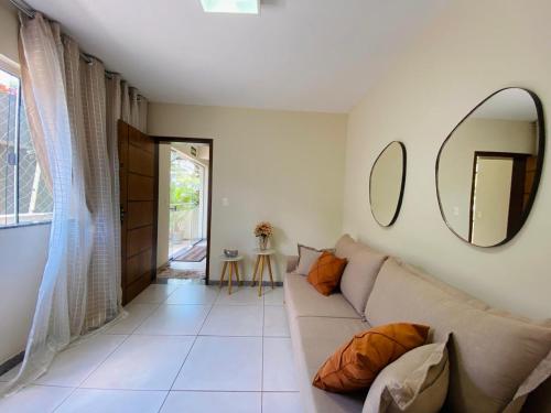 a living room with a couch and a mirror at Apartamento Bela vista in Brumadinho
