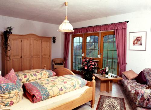 sala de estar con 2 camas y sofá en Café Pension Waldfrieden, en Bad Peterstal-Griesbach