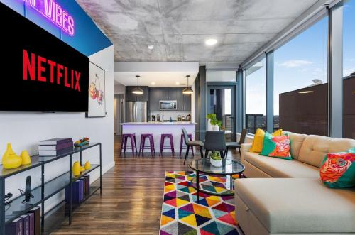 a living room with a television and a kitchen at The Urban Kaleidoscope Downtown Nashville in Nashville