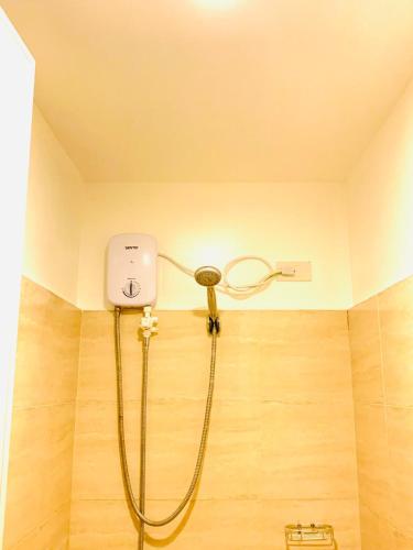 a shower with a hose in a bathroom with a wall at Mabolo Garden Flats 2312 in Cebu City