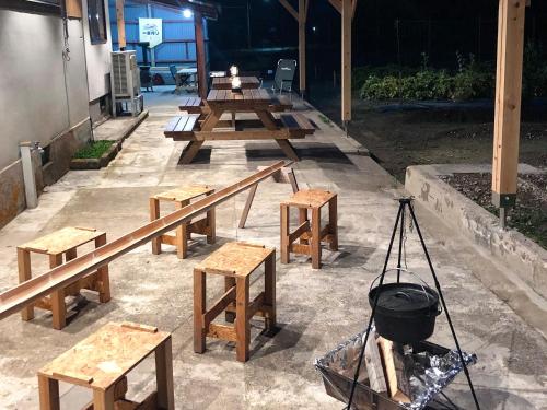 a group of picnic tables and benches with a grill at 畑のおやど in Asago