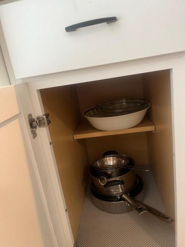 a cabinet with a bowl and a pot and a whisk at Studio Near Beach in Largo