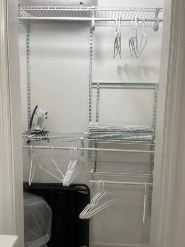 a white closet with a rack with some utensils at Studio Near Beach in Largo