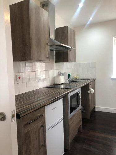 a kitchen with wooden cabinets and a counter top at ASM 23 Lancaster Place in Leicester