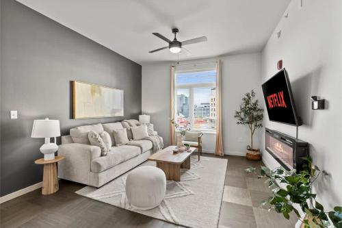 a living room with a couch and a tv at Pinnacle Heights 2Bdrm 3rd flr Near Walmart Amp Pool Fitness Center Yoga Studio Dog Spa in Rogers