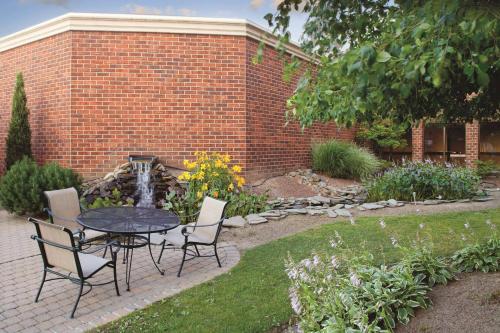 a patio with a table and chairs in a garden at Wyndham Independence in Independence