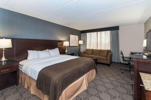 a hotel room with a large bed and a chair at Wyndham Independence in Independence